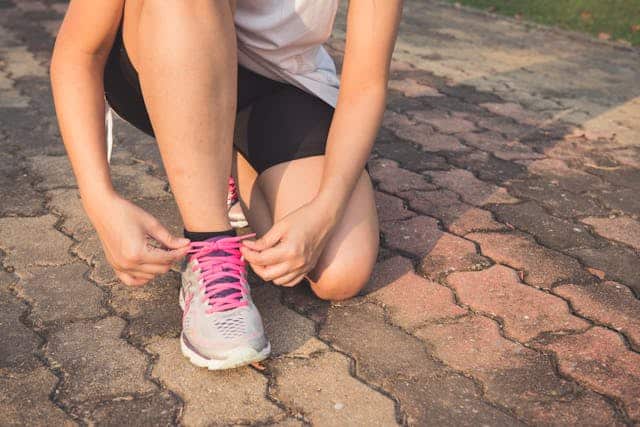 A persons doing their trainer lace up