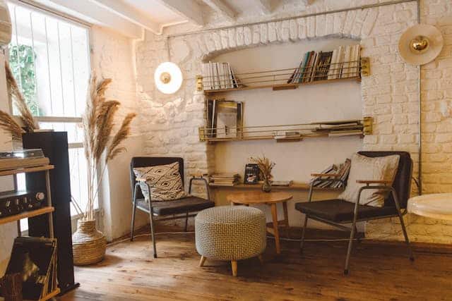 Cream and brown themed living room with two chairs, a coffee table and some shelves