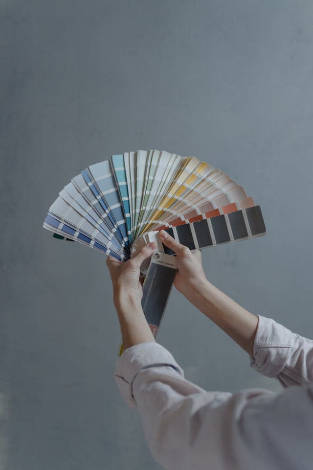 image of hands holding a selection of paint colour charts
